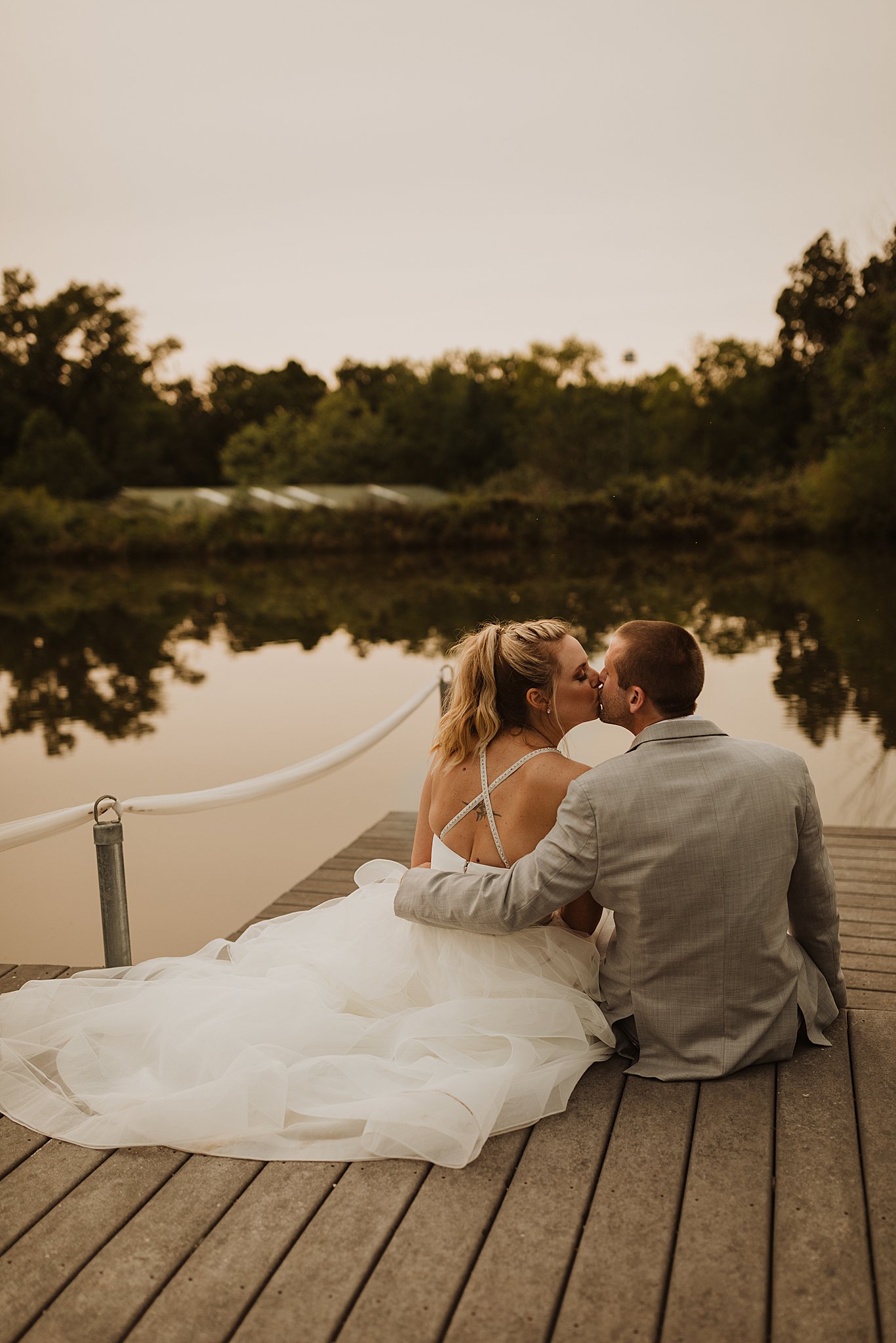 Bride and Groom Kissing on Dock at Little Piney Lodge