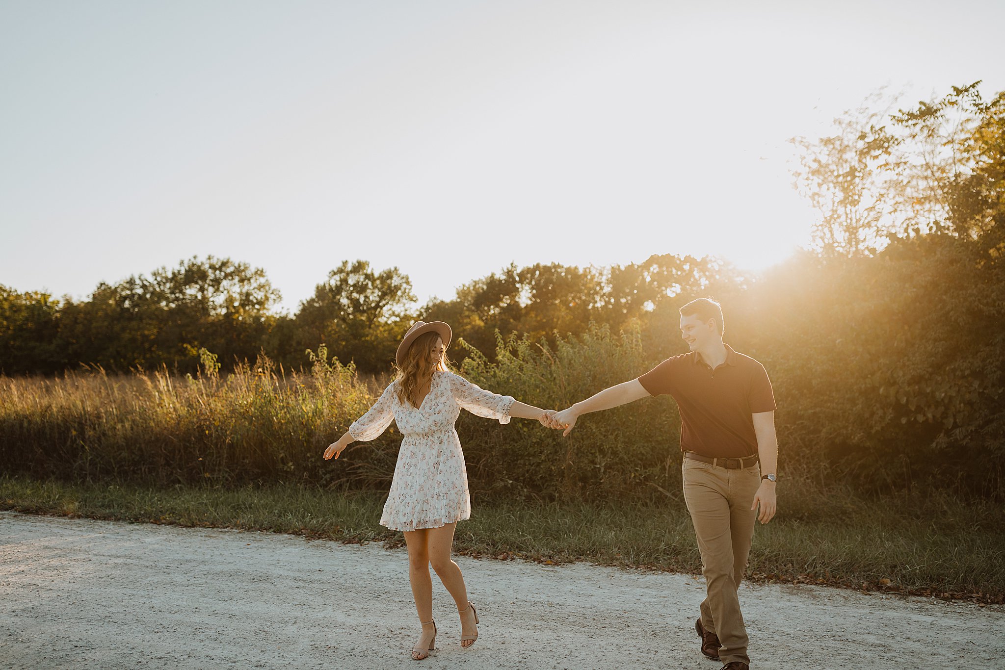 Couple holding hands and walking into the sunset