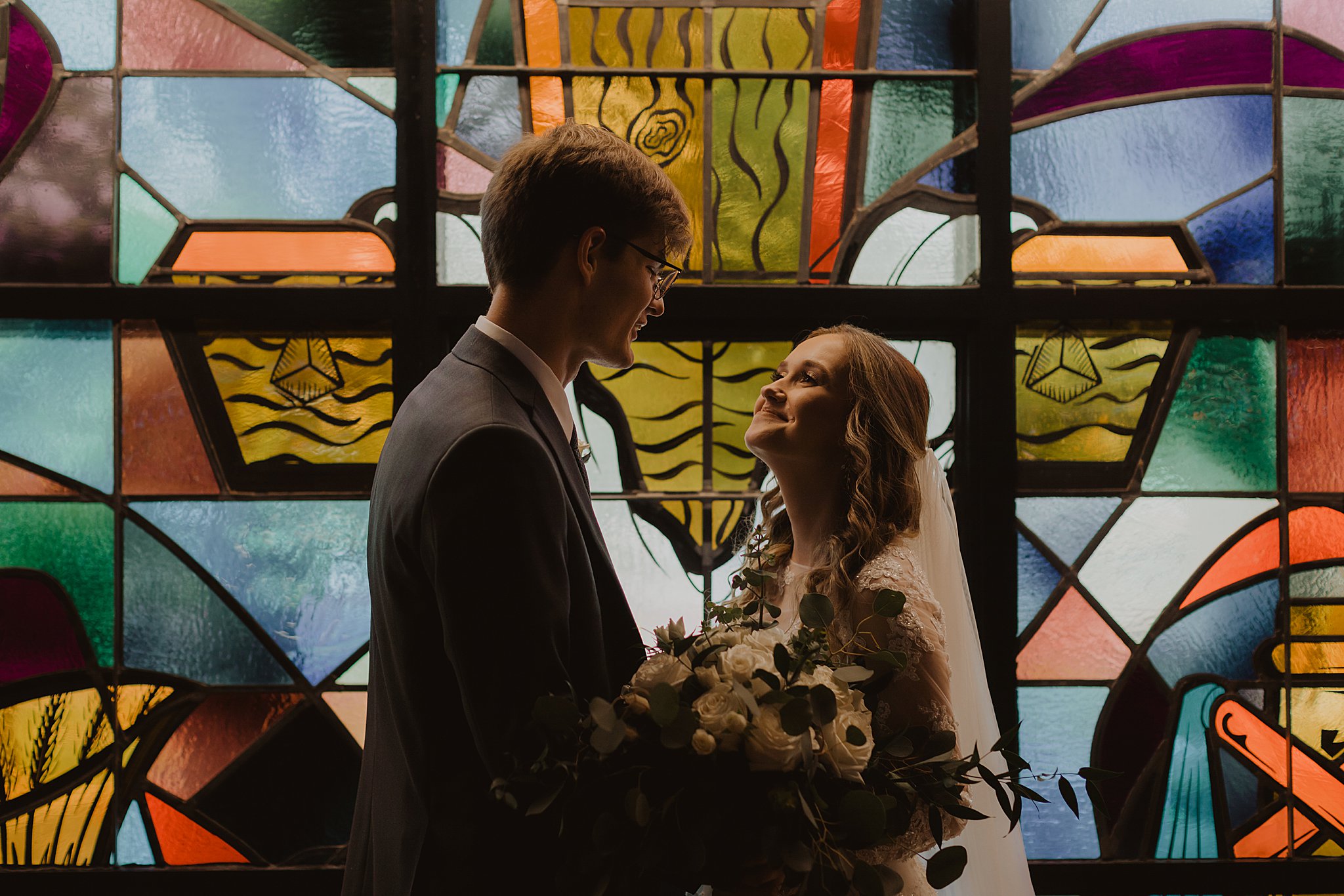 Bride and Groom in front of stained glass window