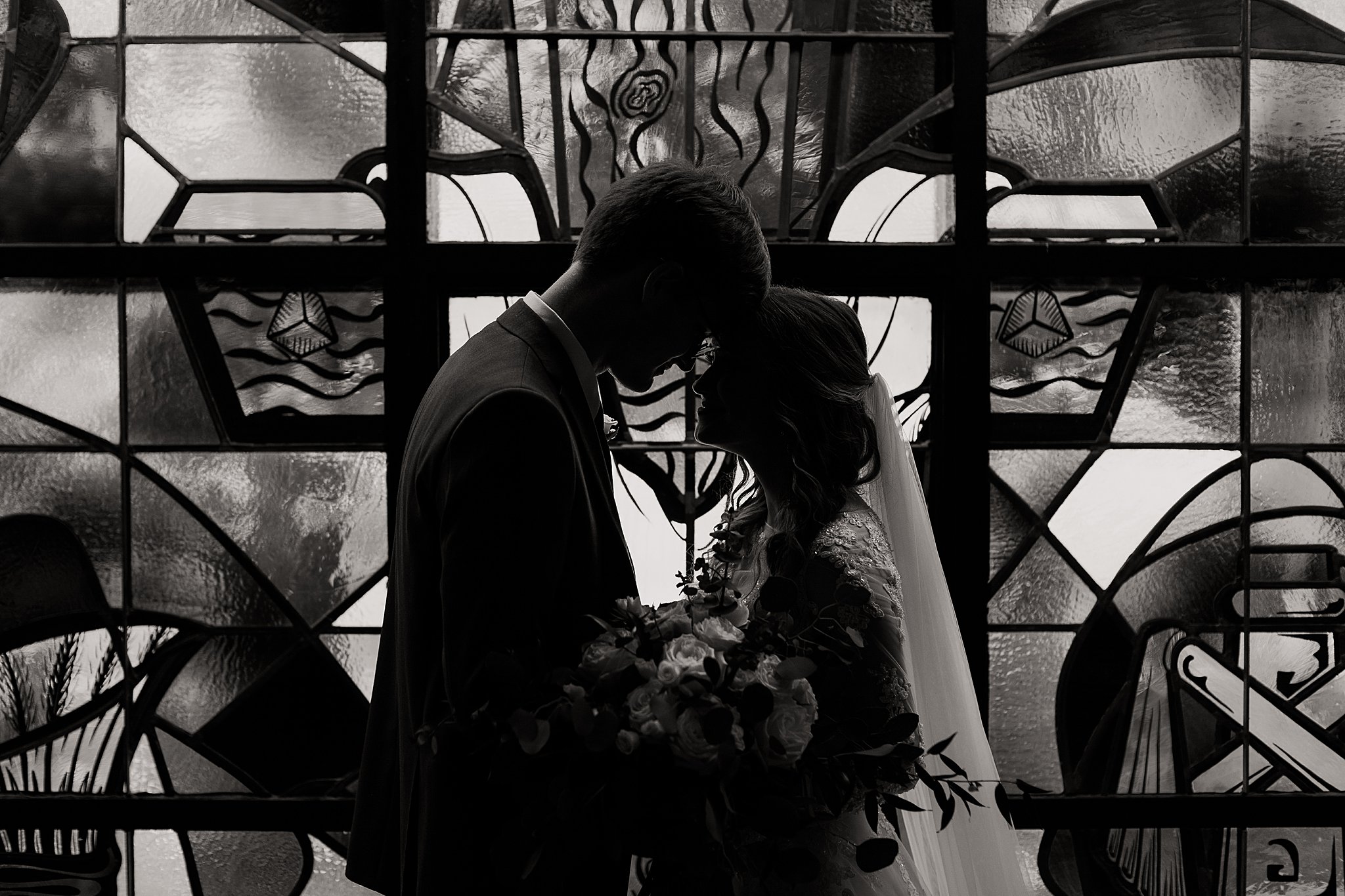 Bride and Groom in Front of Stained Glass Window