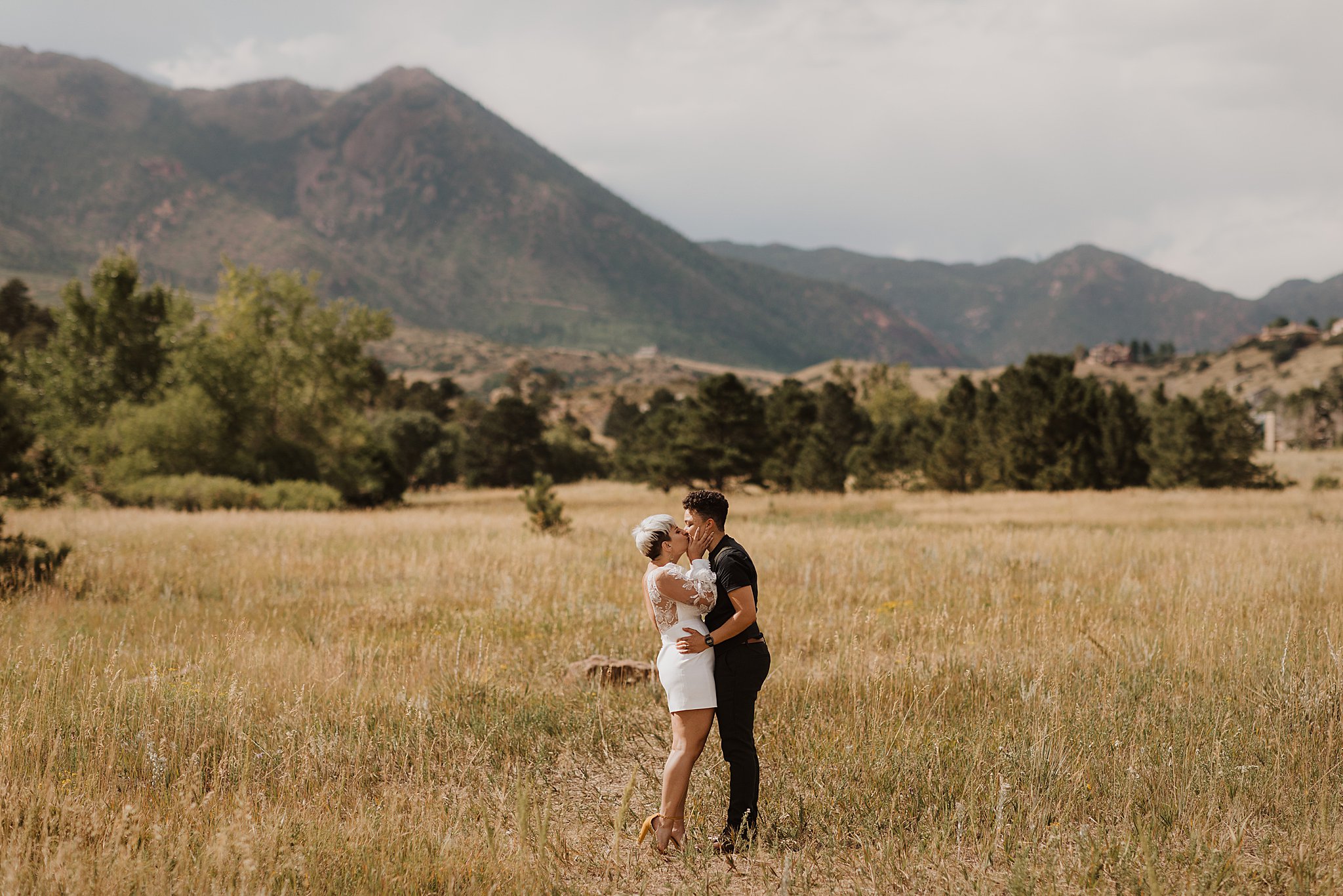 Couple Walking in a Field in Front of Colorado Mountains