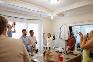 Brides celebrating their summer wedding at Wild Carrot in St. Louis with bridesmaids in pale yellow and chartreuse dresses and bridesmen in beige suits.