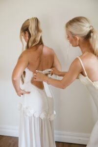 Brides celebrating their summer wedding at Wild Carrot in St. Louis with bridesmaids in pale yellow and chartreuse dresses and bridesmen in beige suits.