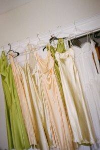 Brides celebrating their summer wedding at Wild Carrot in St. Louis with bridesmaids in pale yellow and chartreuse dresses and bridesmen in beige suits.