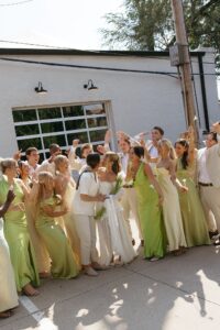Modern LGBTQ wedding at Wild Carrot in St. Louis featuring pale yellow and chartreuse bridesmaid dresses, simple calla lily bouquets, and a brick reception space.