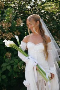 Bride holding elegant calla lily flowers.