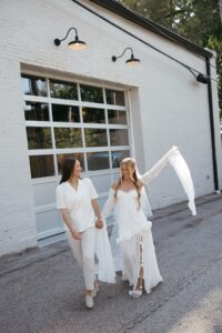 Modern LGBTQ wedding at Wild Carrot in St. Louis featuring pale yellow and chartreuse bridesmaid dresses, simple calla lily bouquets, and a brick reception space.