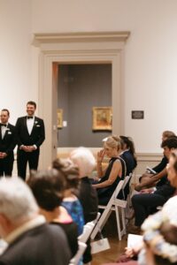 Intimate indoor ceremony during a rainy day St. Louis Art Museum wedding with pastel florals and pale blue bridesmaid dresses.