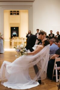 Intimate indoor ceremony during a rainy day St. Louis Art Museum wedding with pastel florals and pale blue bridesmaid dresses.