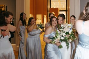 Intimate indoor ceremony during a rainy day St. Louis Art Museum wedding with pastel florals and pale blue bridesmaid dresses.