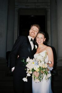 Intimate indoor ceremony during a rainy day St. Louis Art Museum wedding with pastel florals and pale blue bridesmaid dresses.