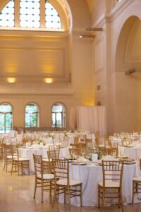 Elegant wedding reception inside the St. Louis Art Museum main hall with pastel floral arrangements and grand architecture.