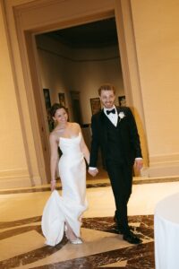 Elegant wedding reception inside the St. Louis Art Museum main hall with pastel floral arrangements and grand architecture.