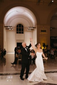 Elegant wedding reception inside the St. Louis Art Museum main hall with pastel floral arrangements and grand architecture.