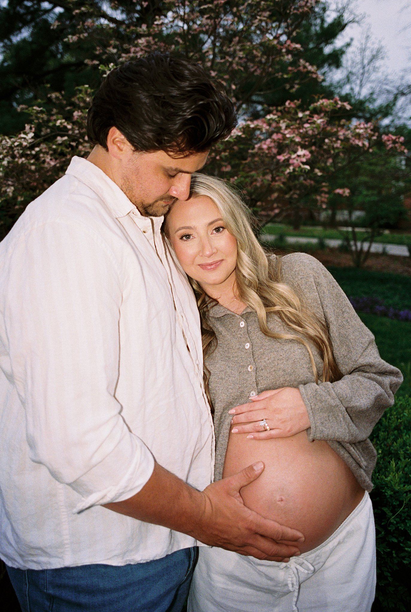 maternity portraits in soft cloudy light on film at Queeny Park with grassy field and blooming trees