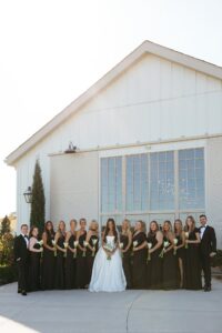bridesmaids in black dresses holding blue hydrangeas and calla lilies at Westwind Hills wedding