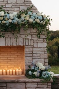 wedding guests enjoying outdoor cocktail hour near the stone fireplace at Westwind Hills