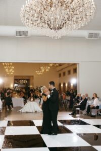 reception at Westwind Hills with black and white dance floor under large chandelier