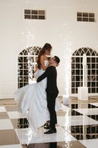 reception at Westwind Hills with black and white dance floor under large chandelier